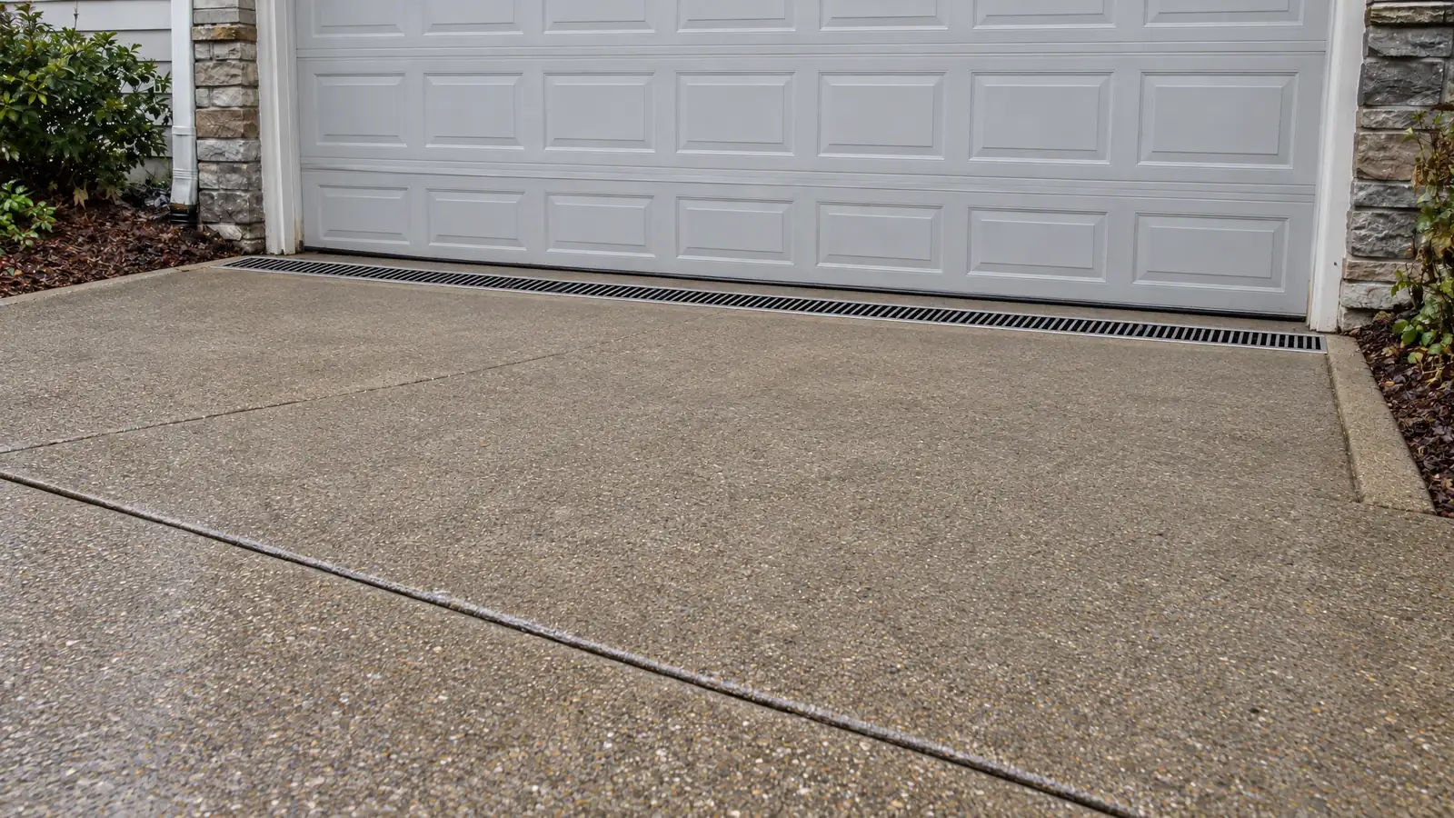 After: the same driveway with a channel drain and a dry garage door